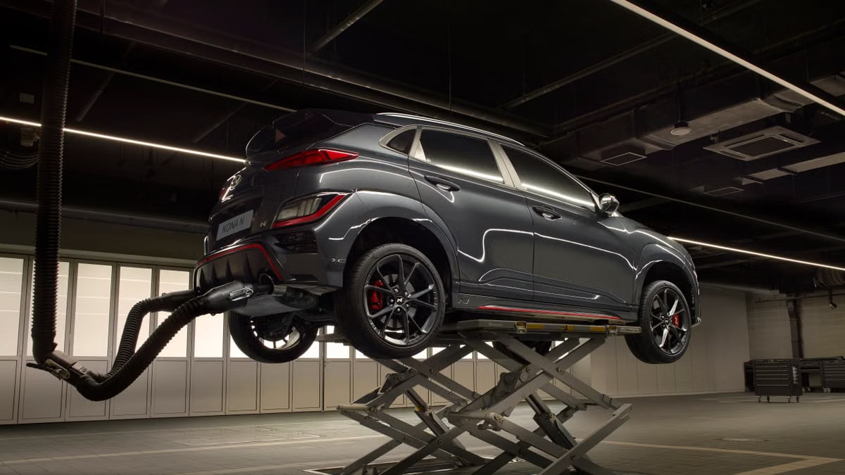 A sleek car on a lift in a high-tech automotive garage.